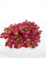 A bunch of dried red rose buds on a white background