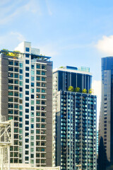 Modern skyscrapers with green terraces and blue sky, showcasing urban architecture and innovative design in a vibrant city environment