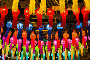 Colorful hanging lanterns in various shapes and sizes create a vibrant atmosphere of asian culture, illuminating the space with festive energy and cultural significance.