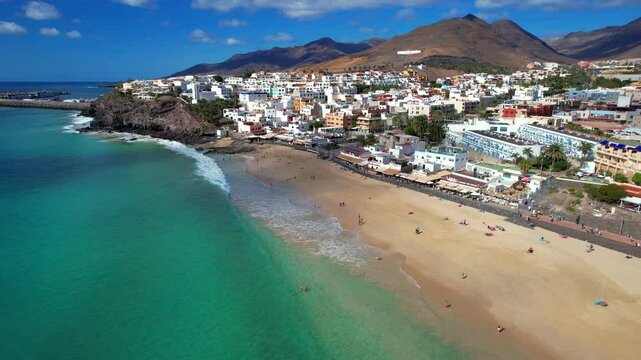 Aerial 4K Drone Flyover of Morro Jable Coastal Town and Endless Sandy Beach in Fuerteventura &mdash; Turquoise Atlantic Ocean and Jandia Peninsula Panorama in Canary Islands