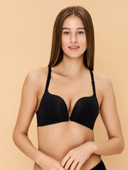 Fototapeta premium Girl model in lingerie posing on beige studio background.