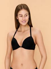 Fototapeta premium Girl model in lingerie posing on beige studio background.