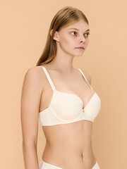 Obraz premium Girl model in underwear posing in studio on beige background.
