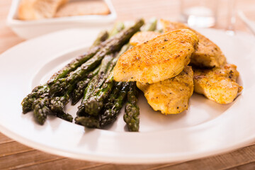 Cooked dish. Chicken nuggets with green asparagus on plate