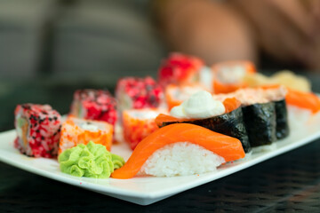 Fresh salmon sushi platter close-up. Artfully arranged assortment of Japanese sushi and rolls featuring premium salmon. Healthy seafood presentation with wasabi and ginger.