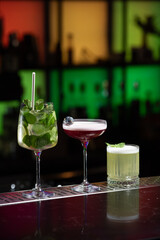 row of various colourfull alcoholic cocktails on a bar desk. Glasses of differen shapes. selective focus
