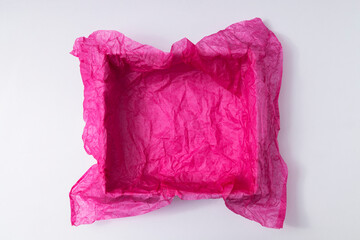 Top view of empty present box and crumpled pink tissue paper for packaging, white background. Space for design or product