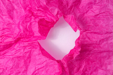 Torn pink tissue paper closeup. Crumpled pink tissue paper with hole