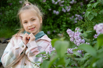 blonde girl posing in blooming lilac