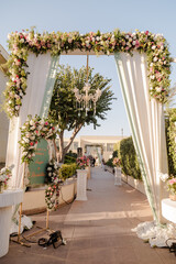 A beautifully decorated wedding entrance with flowers and a chandelier creates a romantic and elegant ambiance. Perfect for a memorable celebration.
