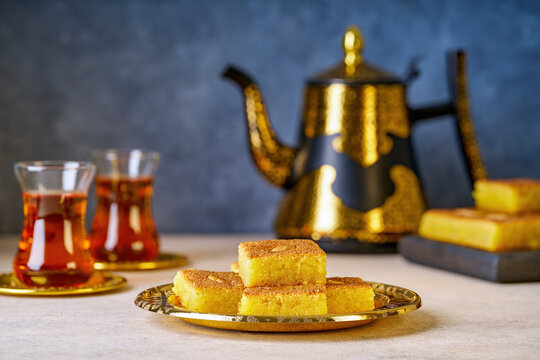 Middle eastern traditional semolina cake basbousa , namoora, hareesa served with tea