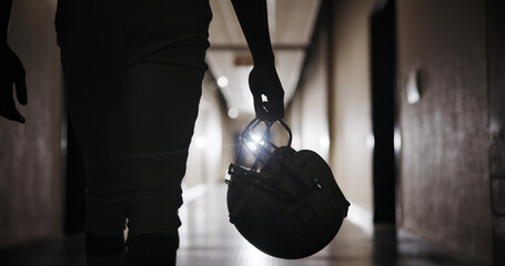 Helmet, football and hands of man in corridor for sports competition, stadium match and game. Fitness, pro league player and athlete with person in tunnel for training, tournament and contest