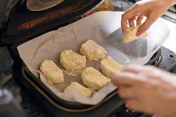 Woman cooking delicious syrniki in the kitchen, close-up.