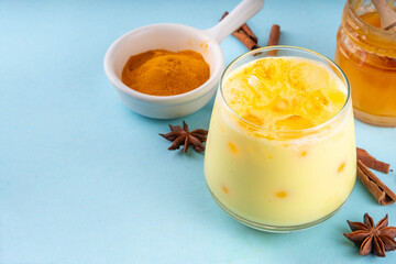 Iced golden milk drink, turmeric latte with ice cubes