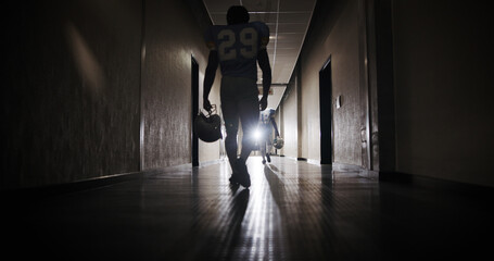Back, football and walking with man in corridor for sports competition, stadium match and game. Fitness, pro league player and athlete with person in tunnel for training, tournament and contest