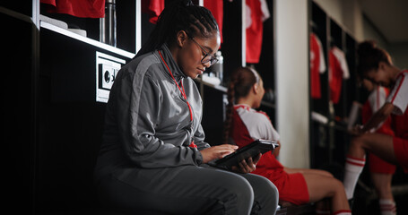 Woman, soccer coach and schedule with tablet for game time, matchup or attendance list in locker room. Female person, manager or coordinator with technology or app for fixtures or player registration