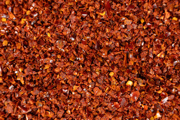 Spicy ground chili pepper close-up texture top view