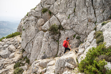 Hiker ascending Puig de Galatz&oacute;, 1027 meters, Calvia-Puigpunyent, Natural area of the Serra de Tramuntana., Majorca, Balearic Islands, Spain