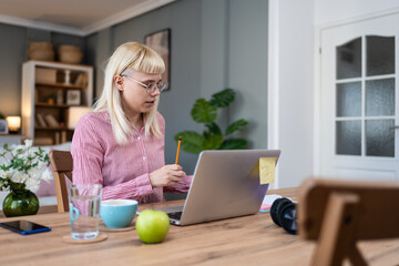 Young freelance business woman having video call conference on laptop computer while sitting and...