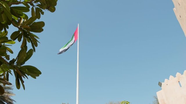 UAE national flag over emirates heritage village and museum in marina island in emirates
