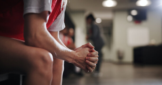 Soccer player, hands and nervous in locker room for competition, sport game or difficult match. Closeup, football or athlete with anxiety or pressure for failure, bad loss or half time on bench