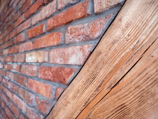Close-up of a rustic wall made of red bricks and natural wood, showing texture and diagonal composition in traditional construction.