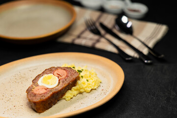 Typical Czech cuisine minced roast pork and beef with egg, sausage and mashed potatoes