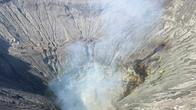 Close view of smoking Bromo volcano crater at sunrise on Java island, Indonesia.