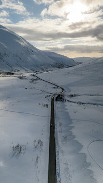 Remote winter road through Nordic snow-covered mountains