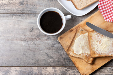 Sliced fresh bread and butter on wooden table. Top view. Copy space