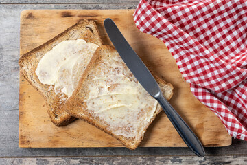 Sliced fresh bread and butter on wooden table. Top view