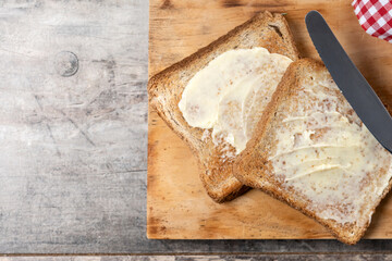 Sliced fresh bread and butter on wooden table. Top view. Copy space