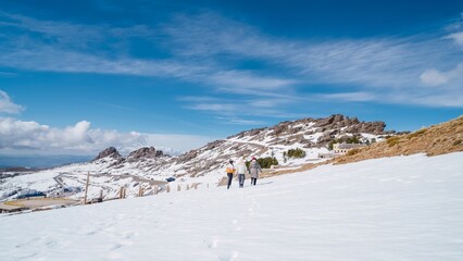 Tourists walking on snow covered mountain road in serra da estrela natural park