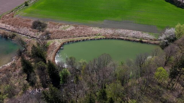 Stunning aerial view of Spiegelweiher serene lake chain near Grafing bei Muenchen, Bavaria, Deutschland. Crystal clear waters, lush spring greenery and trails create perfect scene for nature lovers. 
