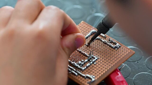 Factory worker soldering a circuit board