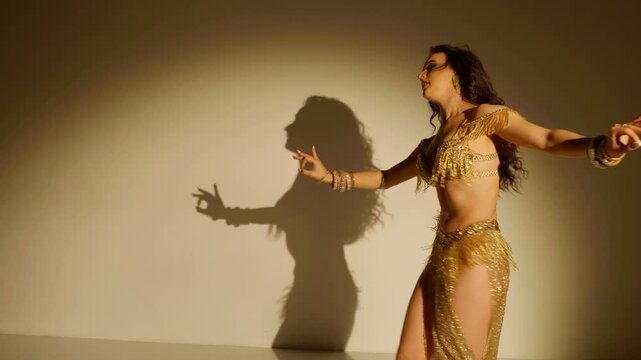 Belly dance artistry, a performance of passion. Elegant dancer, golden light, captivating pose. Golden goddess in motion, a captivating dance. Fluid movements, shimmering attire, a dancer's grace. 