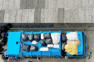 Aerial view show garbage collectors are loading garbage bags onto garbage truck. Image use for presentation background of managing the cleanliness of the city.
