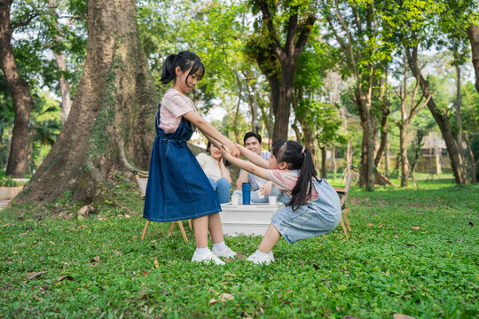 Children enjoy playtime in a lush park, engaging in a tug of war during a sunny afternoon