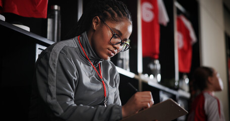 Woman, soccer coach and writing with clipboard for game plan, strategy or attendance list in locker...