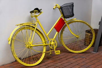 Beautiful side view close up of an old creative bicycle painted yellow.