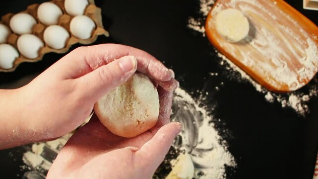 Process of making syrniki. Step 10 - form round syrniki from curd dough. Top view on black surface. Russian cuisine