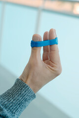 man using an elastic band to exercise his fingers