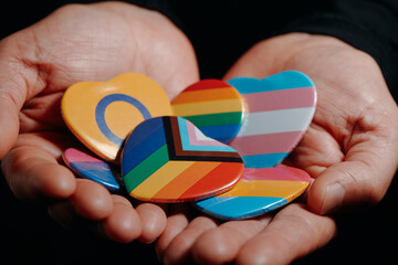 Fototapeta premium man holding badges with different LGBTQ flags
