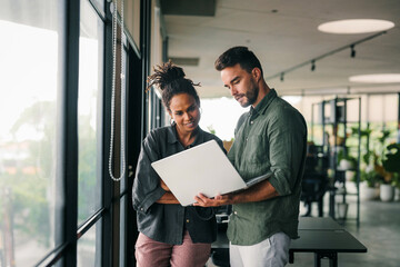 Multicultural professional businesspeople working together on research plan in boardroom.