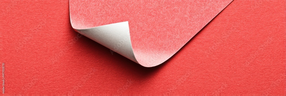 Aufkleber price label sticker partially peeled on vivid red surface creating interesting texture and color con