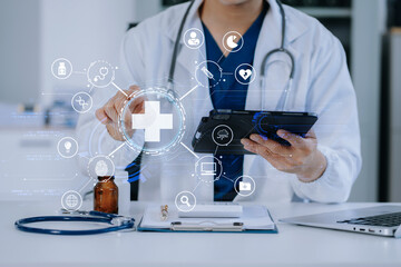 Fototapeta na wymiar Doctor working on laptop and tablet and medical on clipboard on desk, electronics medical record system EMRs concept.