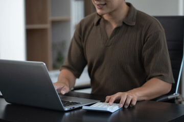 Hand businessman doing finances and calculate on desk about cost at office..