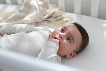 Bedtime. Cute little baby in crib at home, above view