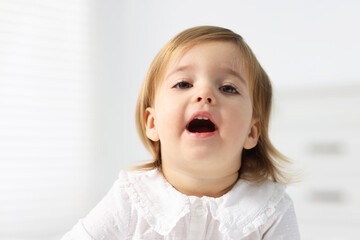 Portrait of cute little baby girl on light background