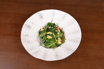 Salad with avocado, herbs, tomatoes in a plate on the table in a restaurant